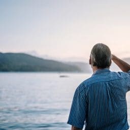 Man stares out at a lake.