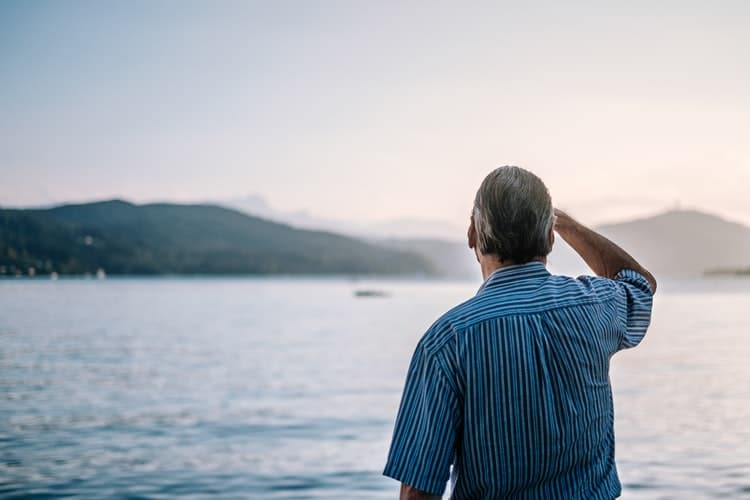 Man stares out at a lake.