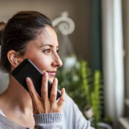 Woman with a hearing aid talking on phone.