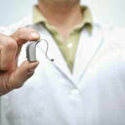 Doctor holding a hearing aid