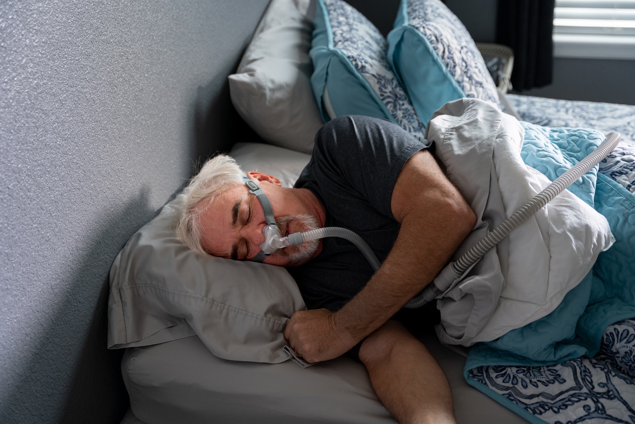 Man sleeping with a CPAP machine.