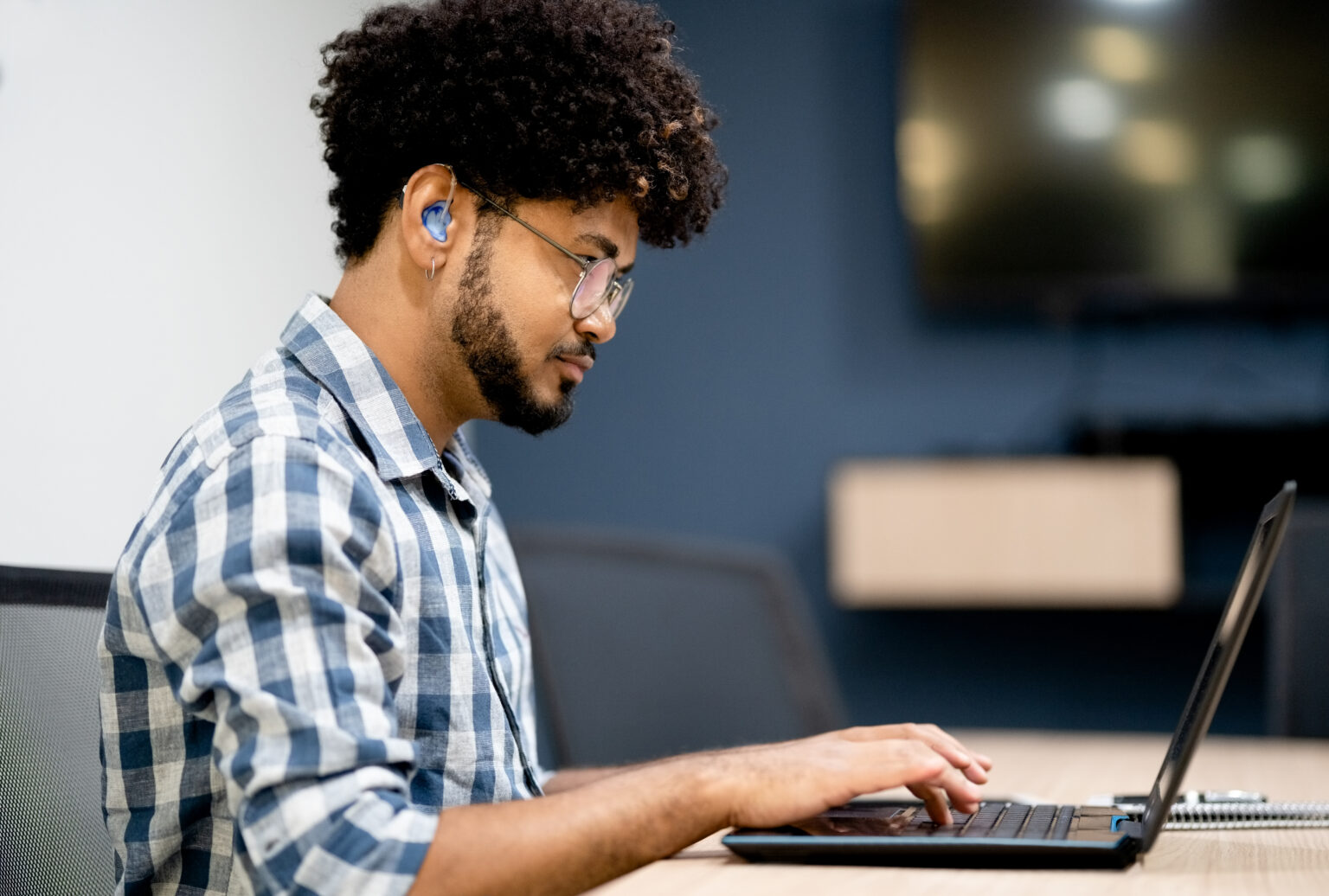 Working man wears a hearing aid to help with tinnitus.