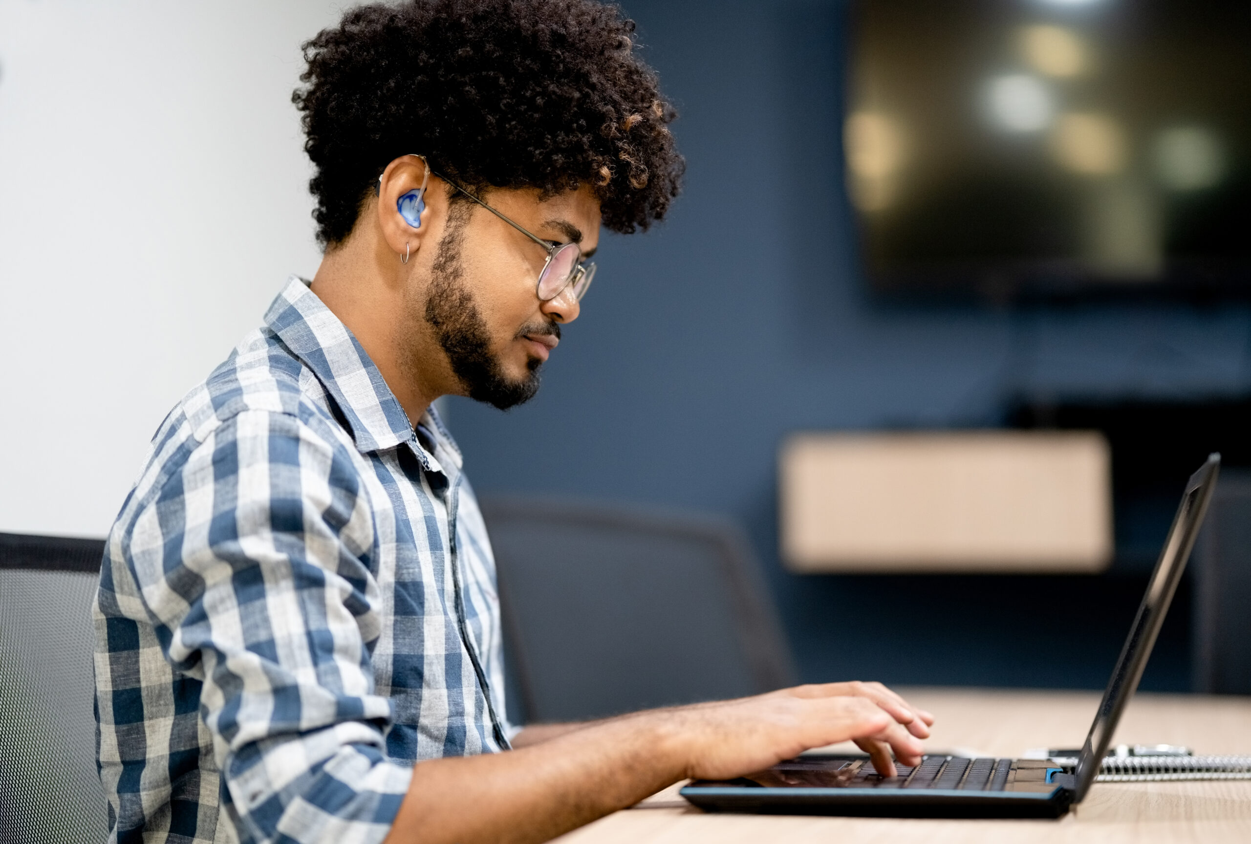 Working man wears a hearing aid to help with tinnitus.